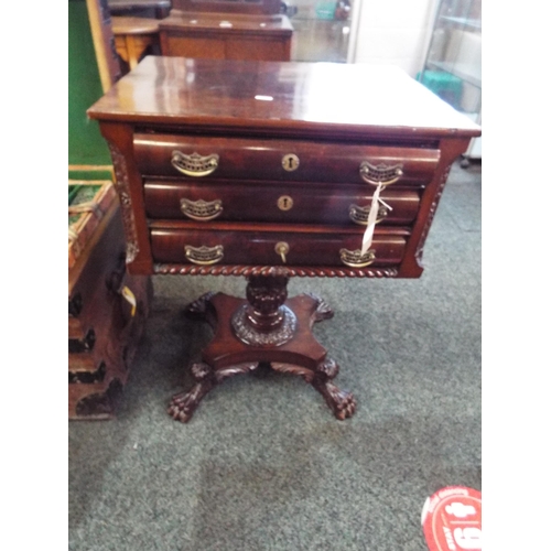 645 - An American mahogany three drawer side table resting on a carved pedestal column and four claw feet