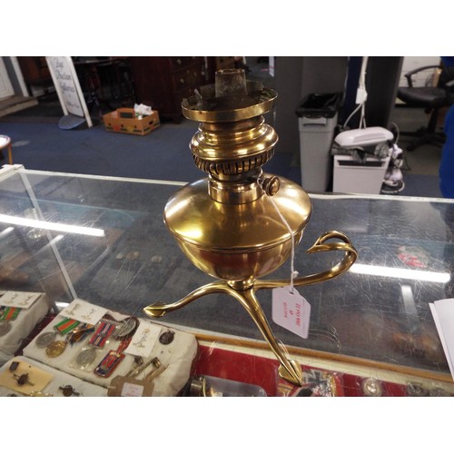 49 - A W.A.S Benson brass art nouveau oil lamp supported on a brass stem with a curved handle and resting... 