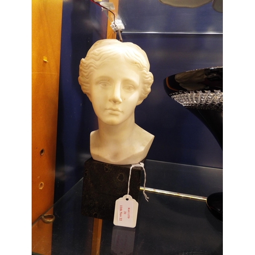 31 - A carved Alabaster head of a young girl resting on a marble plinth