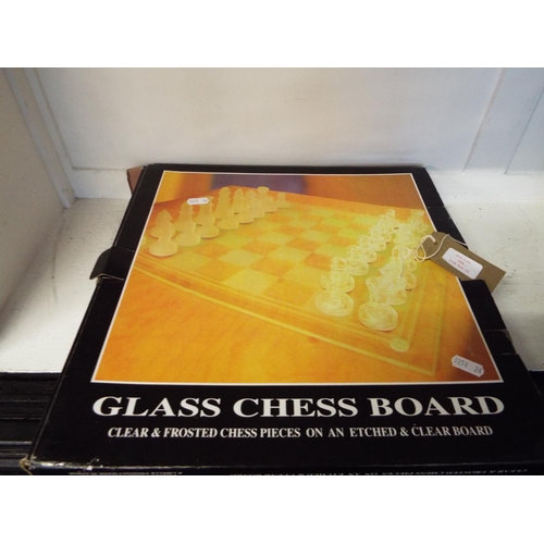 390 - A glass chess board having clear and frosted chess pieces on an etched clear board