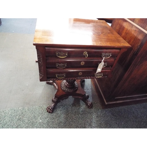 566 - An American mahogany three drawer side table resting on a carved pedestal column and four claw feet