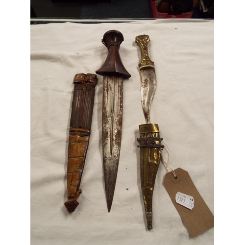 131 - A Middle Eastern dagger with wooden handle and leather scabbard and similar brass example