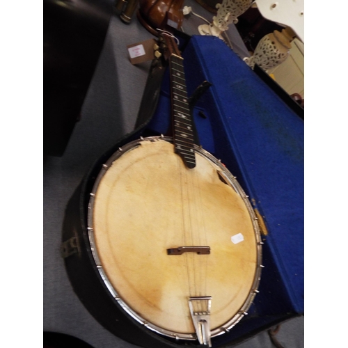 243 - A vintage rosewood banjo ukulele having mother or pearl inlay to fret in case with plectrum and tune... 