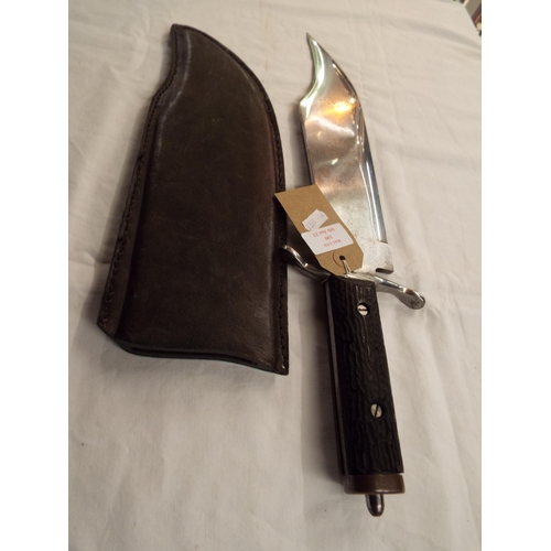 100 - A vintage large bowie knife in leather scabbard