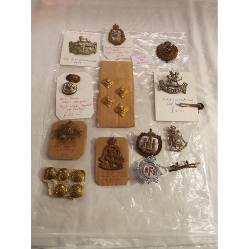 129 - A mixed selection of military cap badges on card and buttons