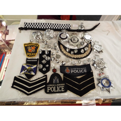 142 - A large selection of Police helmet badges, buttons, cloth insignia