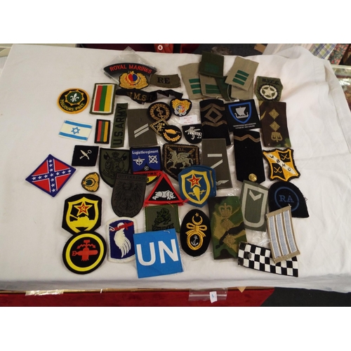 153 - A large mixed selection of USA and British Royal Marine cloth insignia