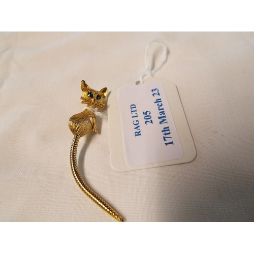 205 - A vintage yellow metal long tailed cat brooch inset with green eyes