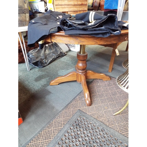 592 - A good quality telescopic circular oak table rising from 18