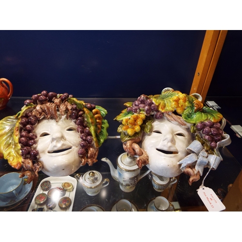 48 - A pair of Italian pottery wall hanging masks decorated with grapes and vines