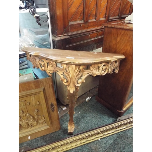 673 - A gilt painted carved hall demi-lune table with glass top