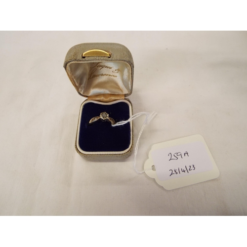 259A - A 9ct gold ring inset with central diamond and two to the shoulders, size O