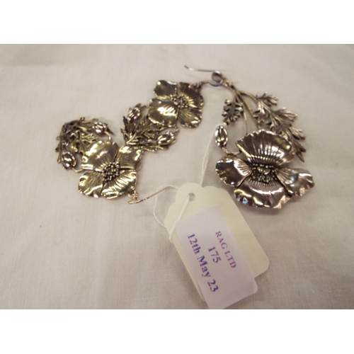 175 - A white metal brooch and matching earrings with poppy decoration