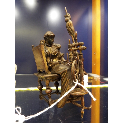 3 - A bronze figurine of a female seated at her spinning wheel