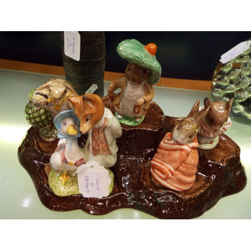 63 - A Beswick tree bark five place stand with Royal Albert Mrs Titmouse, Mr Aldeman Ptomel, Poorly Peter... 