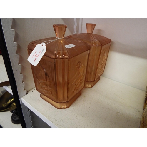 388 - A pair of pink glass art deco lidded jars with embossed female decoration