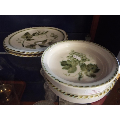 104 - Two Rye pottery dinner plates and two shallow bowls with hop and vine decoration