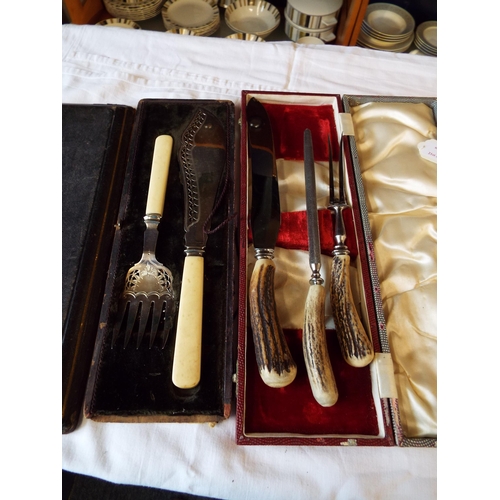 110 - A boxed antler handled carving set together with a bone handled carving set