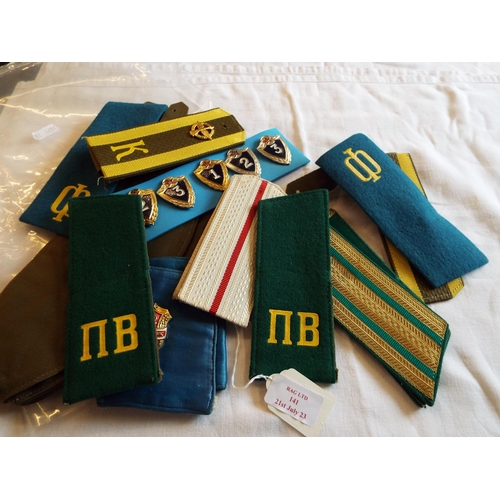 141 - A selection of Russian items to include cap, arm band, shoulder boards etc