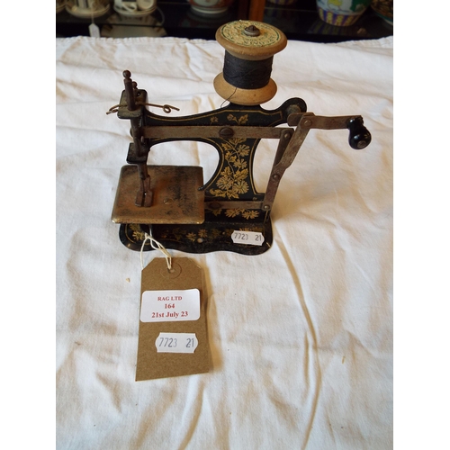 164 - An early toy sewing machine with gold floral painted decoration, makers stamp Muller’s Kiner-Nahmasc... 