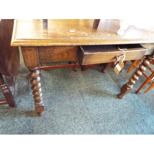 602 - An oak hall table having frieze drawer resting on barley twist supports