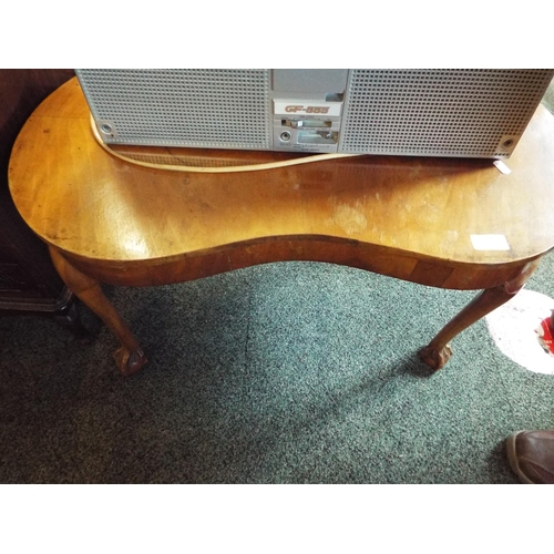 610 - A quarter veneered kidney shaped coffee table resting on claw and ball feet