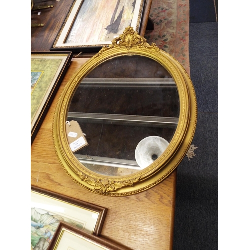 514 - An oval Victorian gilt frame wall mirror with a moulded floral decorated top