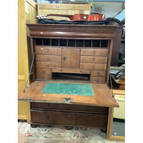 660 - A 19thC Continental mahogany Escritoire the flap enclosing pigeon holes and drawers above two short ... 