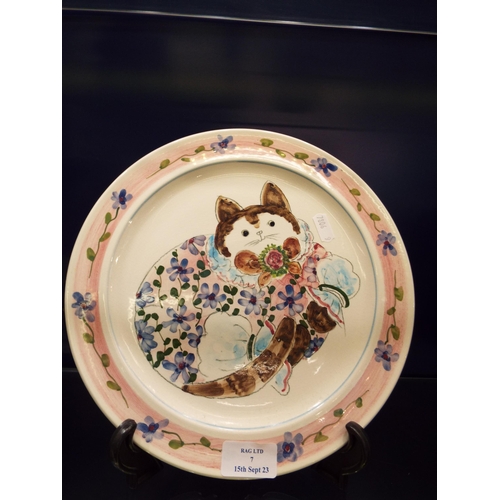 7 - A Cinque Ports pottery plate with hand painted decoration in the style of Joan De Bethel, 10 1/2