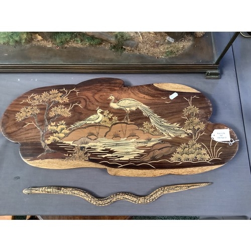 543 - A wooden inlaid wall plaque with peacock etc decoration together with a wooden articulated snake