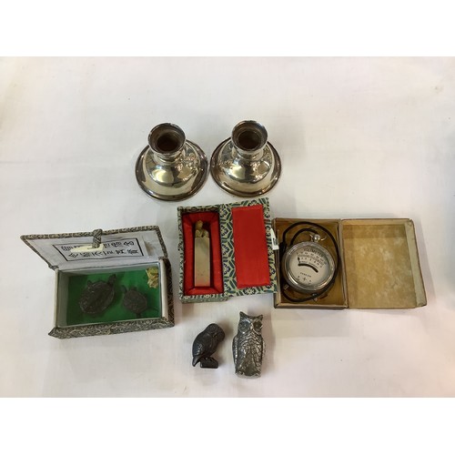 176 - A mixed selection of items to include two silvered candle holders, two metal models of owls, a box c... 