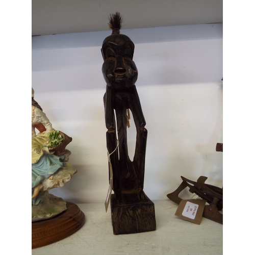 443 - A mid-20thC carved wooden statuette of a man having a tuff of bristles on his head from Kenya Africa