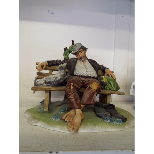 445 - A signed Capodimonte figural group of a tramp and dog resting on a bench