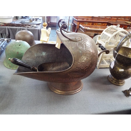 297 - A hand beaten copper coal scuttle with shovel