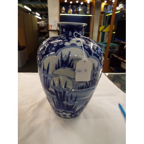 66 - An Oriental blue and white china vase having prunus and water iris decoration