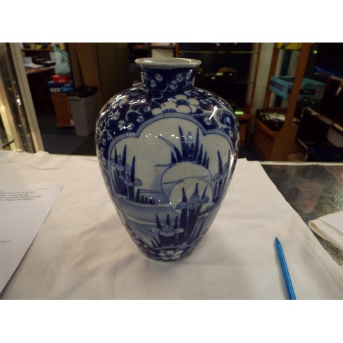 66 - An Oriental blue and white china vase having prunus and water iris decoration