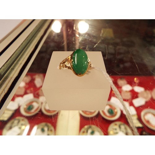 228 - A gold ring inset with an apple green natural Chinese jadeite gemstone, size N