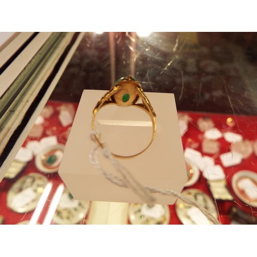 228 - A gold ring inset with an apple green natural Chinese jadeite gemstone, size N