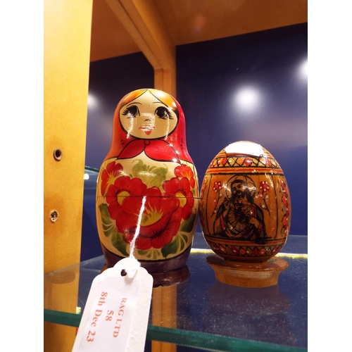 58 - A set of seven Russian Matryoshka dolls together with a religious icon egg resting on stand