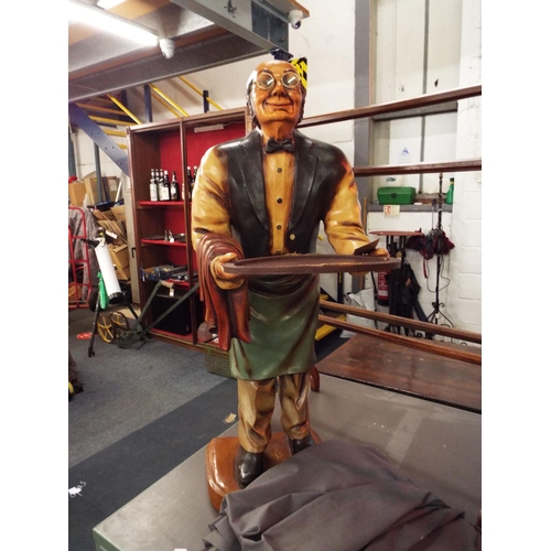 619 - A resin figural model of a male waiter with tray raised on a plinth 37