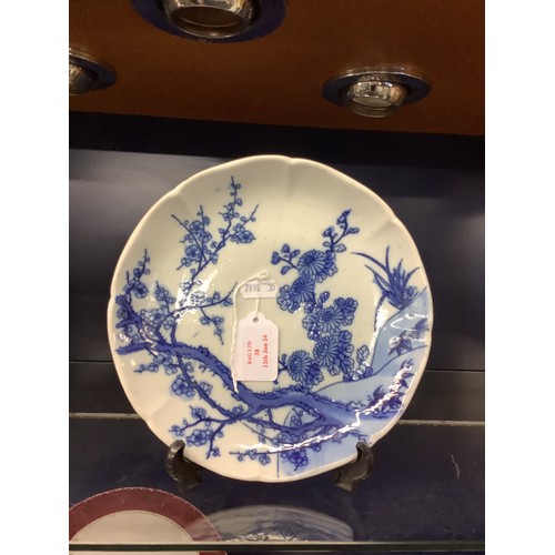 38 - An Oriental plate having prunus decoration marks to rear