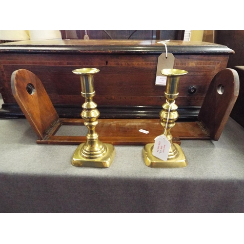 358 - A Victorian walnut and brass book slide together with a pair of brass candlesticks