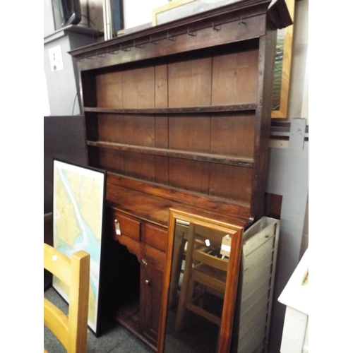 509 - An early 19thC oak dresser the top having two plate racks above three short drawers, pot cupboard fl... 