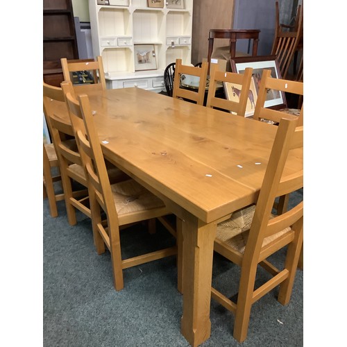 512 - A good quality oak farmhouse four plank top refectory table eight ladder back chairs with rush seats