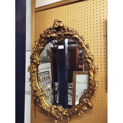 450 - A circular gilt framed plaster mirror having floral decoration