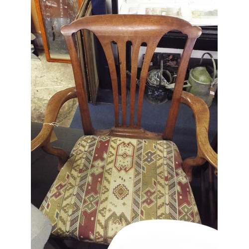 483 - A Georgian oak framed elbow chair with scrolled arms and tapestry upholstered seat