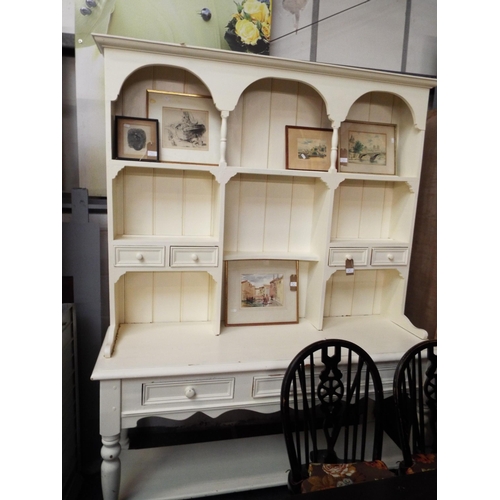 508 - A vintage white painted pine dresser the top having plate racks and four short drawers above three s... 