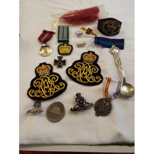 140 - A mixed selection of military items to include cloth badges, lapel badges, ribbons, medals, plumb et... 