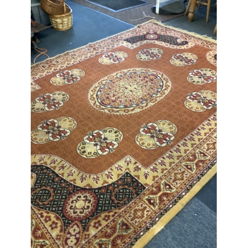 535 - An orange and brown ground rug with stylised decoration A/F