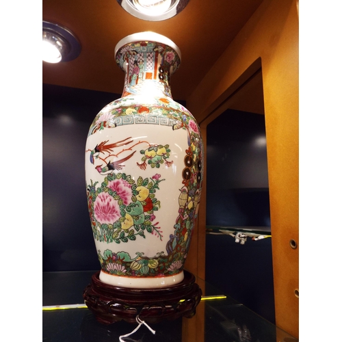 55 - A Chinese hand-painted vase having pictorial panel depicting floral decoration resting on a hardwood... 